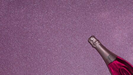 Bottle of pink champagne in bright light on a shiny backgroundの写真素材