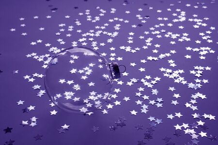 Transparent Christmas decorative ball with stars on a purple background.の写真素材