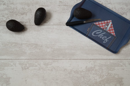 avocado with knife on wood background