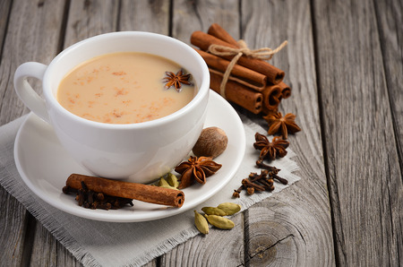 Indian masala chai tea. Spiced tea with milk on the rustic wooden table. Horizontal permission. Selective focus.の写真素材