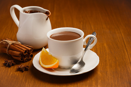 Hot chocolate with orange and spices on the wooden table. Horizontal permission. Selective focus.の写真素材