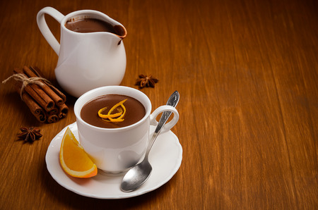Hot chocolate with orange and spices on the wooden table. Horizontal permission. Selective focus.の写真素材