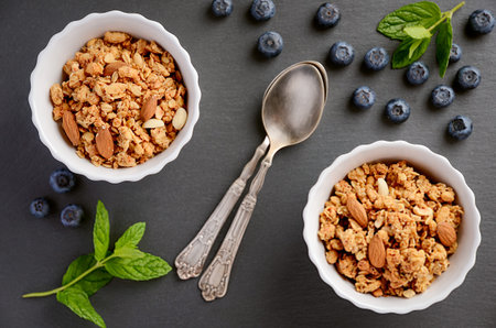 Homemade granola with blueberries on black background, top view
