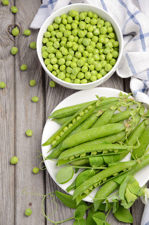Fresh green peas on wooden backgroundの写真素材
