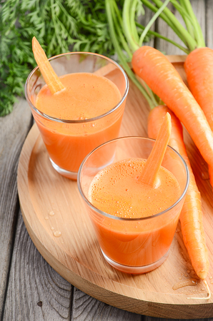 Fresh carrot juice on wooden background, selective focusの写真素材