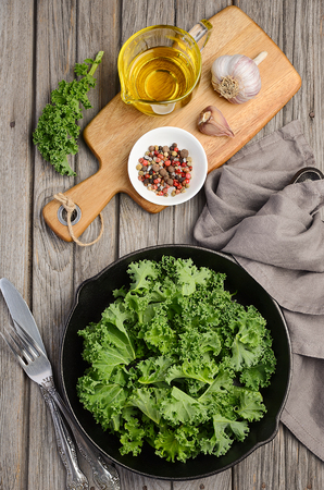 Fresh kale with olive oil, garlic and pepper, top viewの写真素材