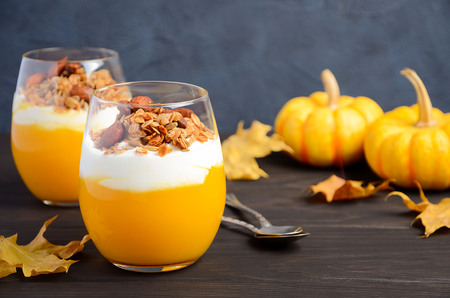 Pumpkin dessert with yogurt and homemade granola on dark wooden table, selective focus, copy spaceの写真素材