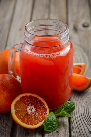 Fresh blood orange juice on wooden background, selective focus, copy spaceの写真素材