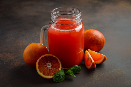 Fresh blood orange juice in mason jar on dark background, selective focus, copy spaceの写真素材