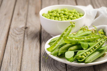Fresh green peas on rustic wooden background, selective focus, copy spaceの写真素材