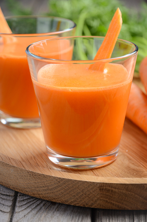 Fresh carrot juice on wooden background, selective focusの写真素材
