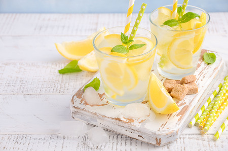 Cold refreshing summer drink with lemon and mint on wooden background.の写真素材