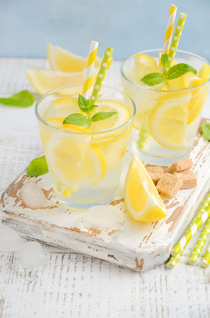 Cold refreshing summer drink with lemon and mint on wooden background.の写真素材
