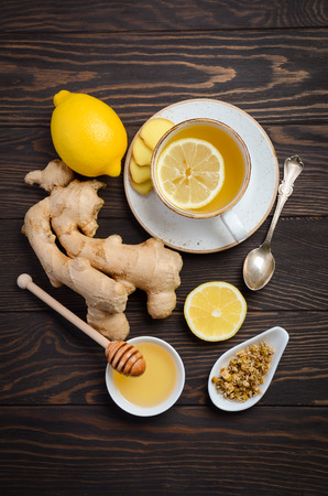 Ginger root tea with lemon and honey on a wooden background, top viewの写真素材