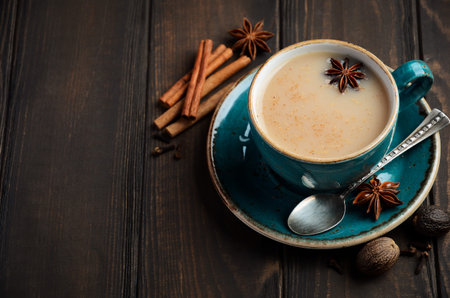 Indian masala chai tea. Spicy tea with milk on dark wooden background.