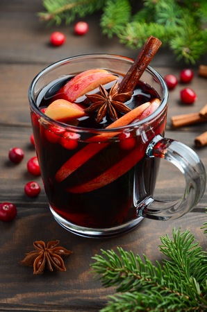 Christmas Mulled Wine with Apple and Cranberries. Holiday Concept Decorated with Fir Branches, Cranberries and Spices.の写真素材