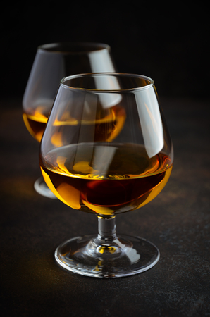 Glass of whiskey with ice on the old rusty backgroundの写真素材