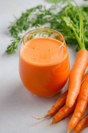 Fresh carrot juice on a gray concrete background, selective focus.の写真素材