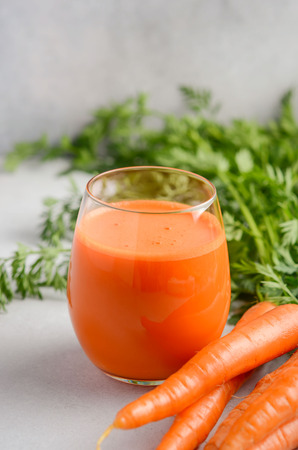 Fresh carrot juice on a gray concrete background, selective focus.の写真素材