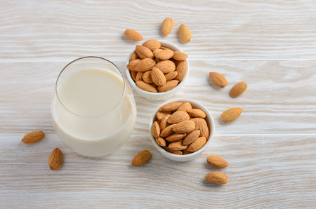 Almond milk and almonds on a white wooden background, selective focus.の写真素材