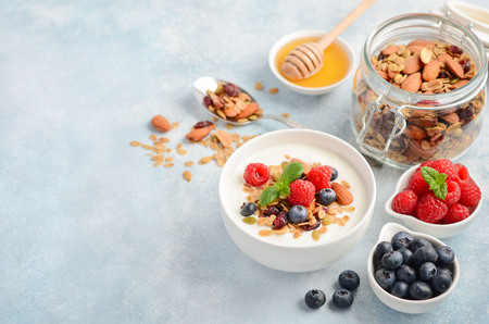Homemade granola with yogurt and fresh berries, healthy breakfast concept, selective focus.の写真素材