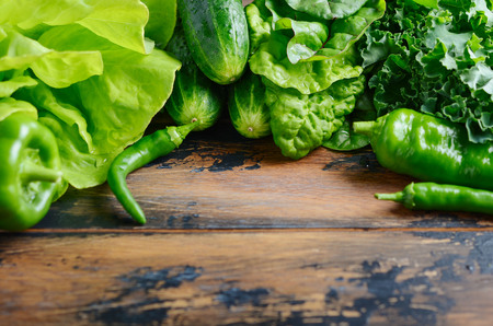 Fresh green organic vegetables on old wooden table.の写真素材