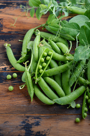 Fresh organic green peas on rustic wooden background.の写真素材