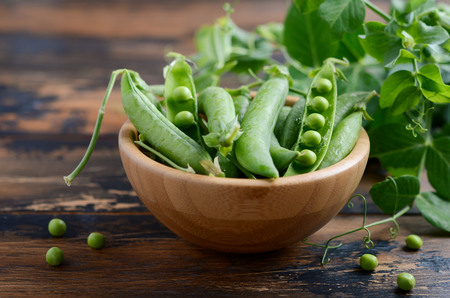 Fresh organic green peas on rustic wooden background.の写真素材