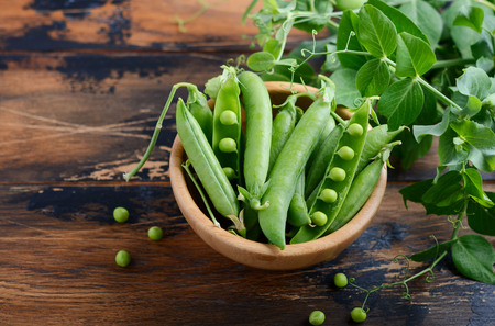 Fresh organic green peas on rustic wooden background.の写真素材