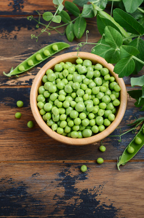 Fresh organic green peas on rustic wooden background.の写真素材