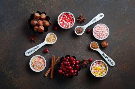 Christmas baking decorations, spices, nuts, berries and sprinkles on a dark background, Holiday concept Top view, Flat layの写真素材