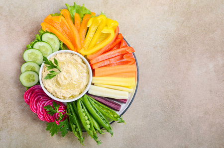 Hummus platter with assorted vegetable snacks. Healthy vegan and vegetarian food. Top view, flat lay, copy space.の写真素材