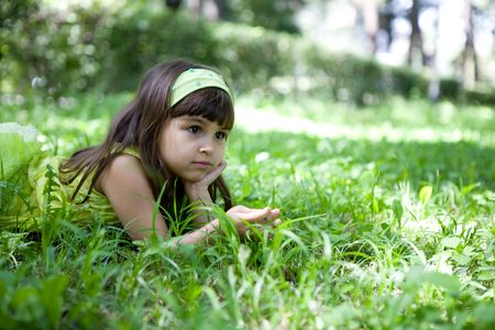 Beautiful curious girl  in a summer parkの写真素材