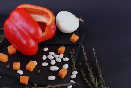 Open space. Vegetables for cooking in the lobby are on a dark platter. Bulgarian pepper, beans, carrots and onions. Ingredients for cooking homemade and wholesome food. Healthy eating conceptの写真素材