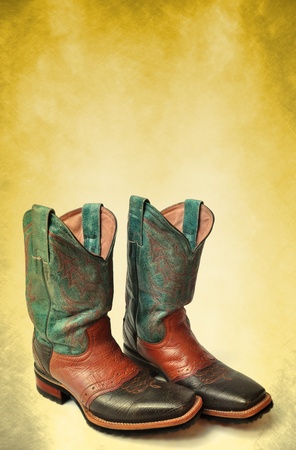 Dirty rodeo old boots leather on vintage background backgroundの写真素材