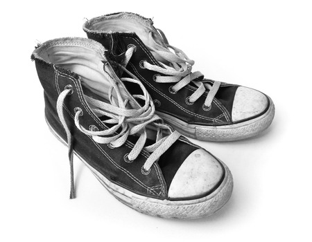 Old black sneakers on a white backgroundの写真素材