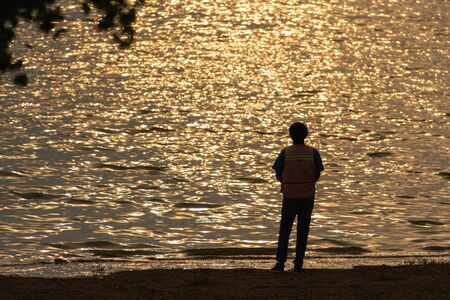 Fisher man Fishing with spinning rod on a lake beautiful sunrise.の写真素材