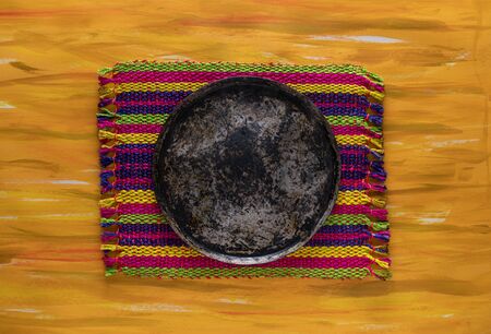 Mexican Comal Cookware flat Griddle used to cook Tortillas on Woven Tablecloth.の写真素材