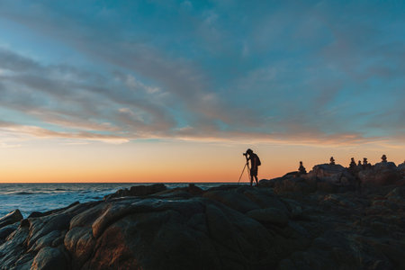 Photographer on Cliff and Beautiful Sunset in Mexican beach.の写真素材