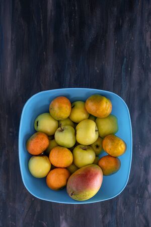 Mandarin Oranges, Apple and Mango Fresh Fruit on Blue Tray.の写真素材
