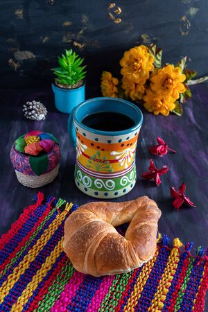 Mexican Cuernito Bread, Sugar Croissant and Coffee Jar on Woven Tablecloth.の写真素材