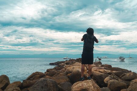 Photographer on Cliff and Beautiful Sunset in Mexican beach.の写真素材