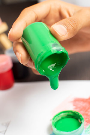 Close-up of a female hand painting with gouache on paperの写真素材