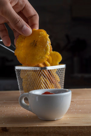 Sweet potato chips and cup of coffee on wooden table