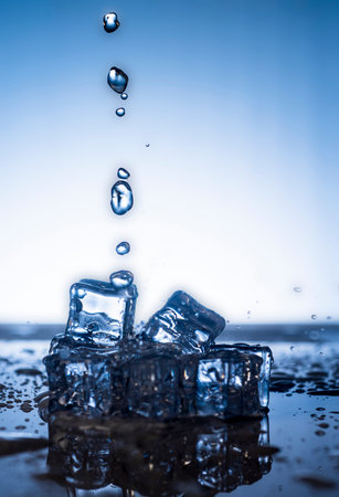Ice cubes with water drops on blue background. Copy space for text.