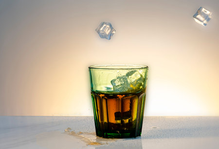 Glass of whiskey with ice cubes on a white background. Copy space.