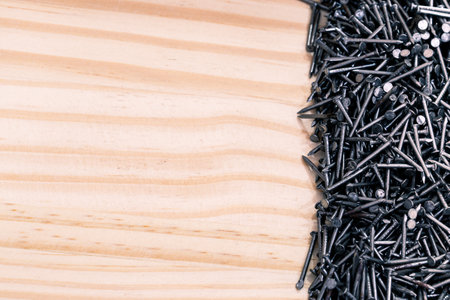 A set of nails piled up in a light wooden plank. Macrophotographyの写真素材