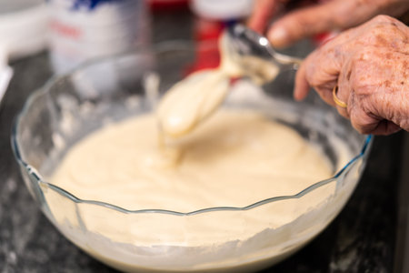 Close-up at Grandmother's hand preparing a delicious cake. Cooking time.の写真素材