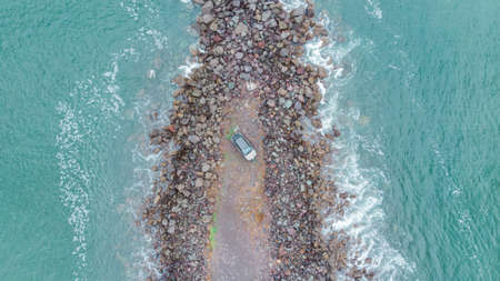 Vehicle by the sea on the stonesの写真素材