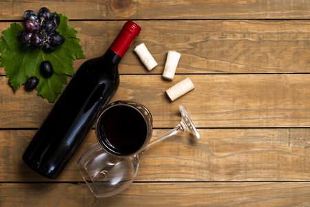 Bottle of wine and glasses and grapes on wooden background. Top view with copy space.の写真素材